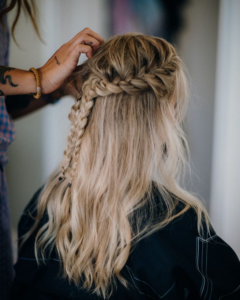 Alumna haciendo un peinado con trenzas a una clienta